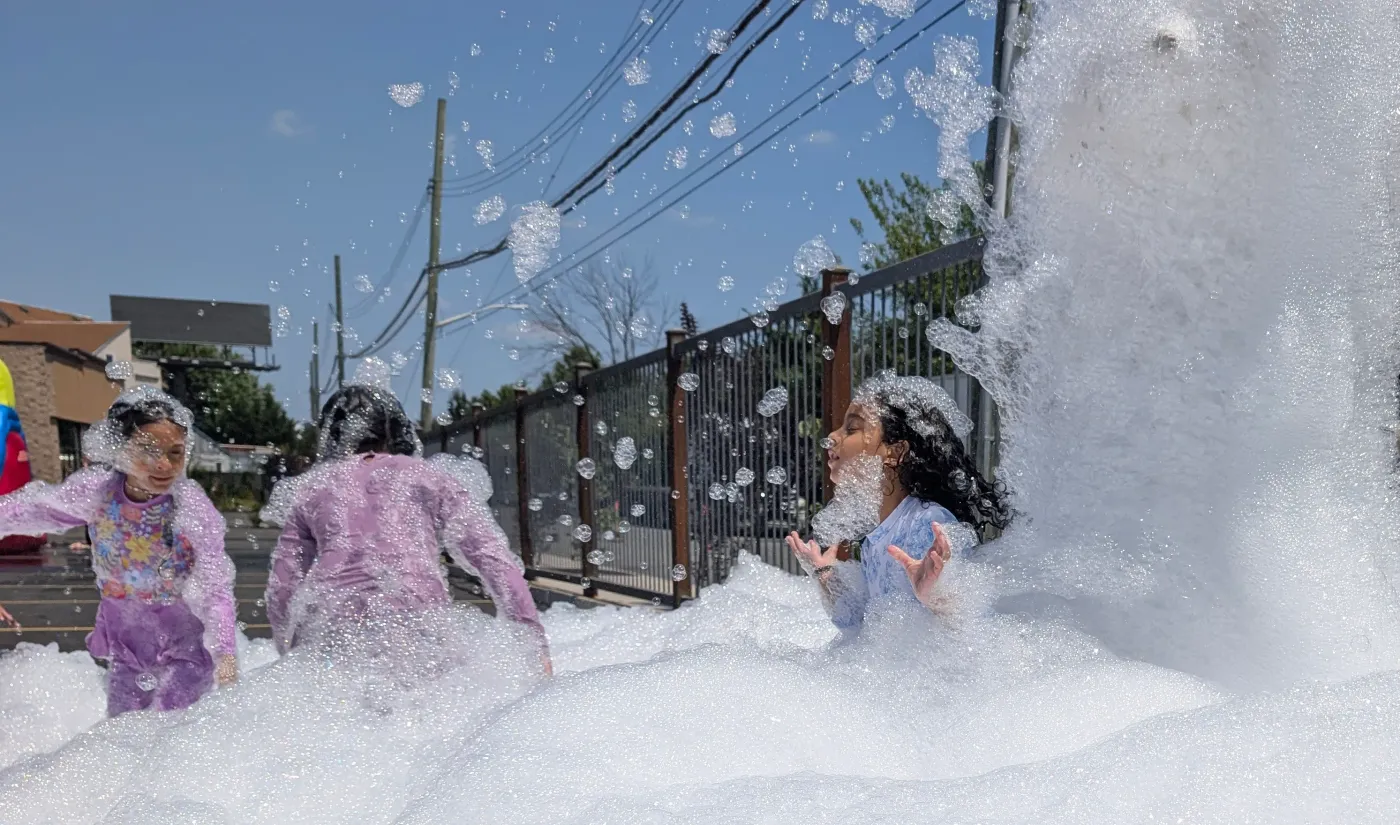 Foam spraying across an outdoor party
